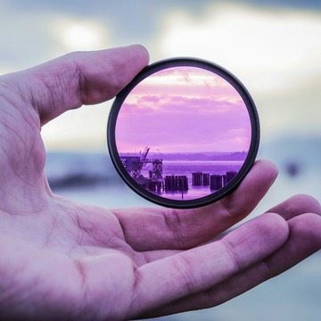 hand holding a purple lens